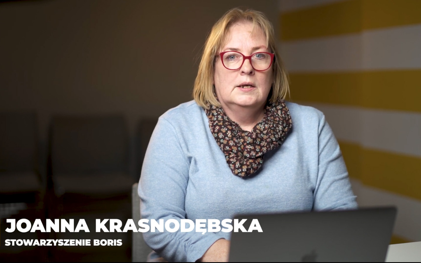 Osoba siedząca przed otwartym laptopem, z podpisem "Joanna Krasnodębska. Stowarzyszenie BORIS"